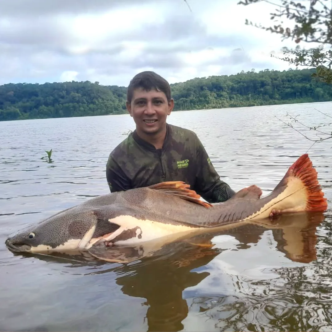 Pescador segurando uma pirarara capturada perto da Triple Borders Lodge